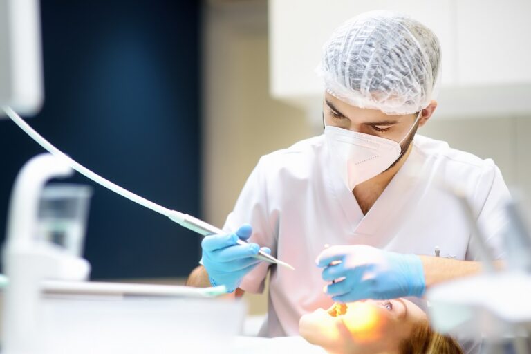 Dentist and patient at modern medical center. Doctor treats a young woman teeth in hospital. Practitioner examines the patient before orthodontists or prosthetics treatment.